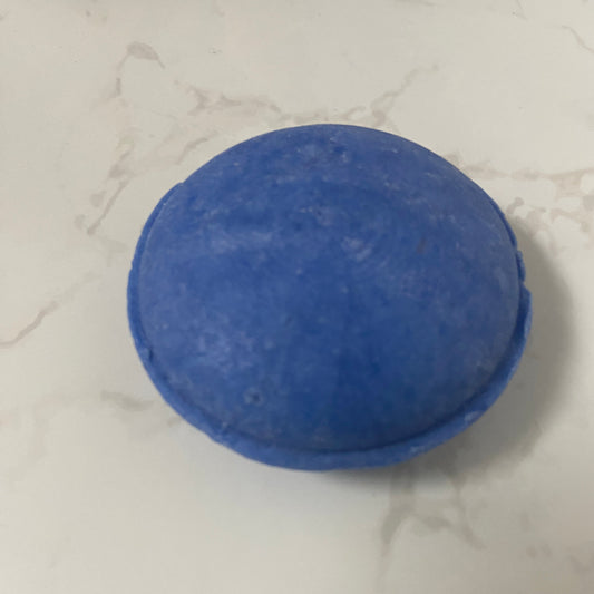 Blue cicular blue shampoo bar on a marble background